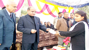 Deputy Chief Minister Tara Chand distributing scholarship cheque to a student at Jammu on Wednesday.