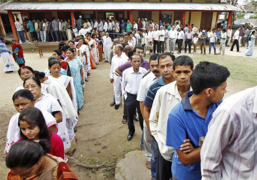 Voters line up to cast their vote outside a polling station in Nakhrai village in Tinsukia district of Assam on Monday (UNI)
