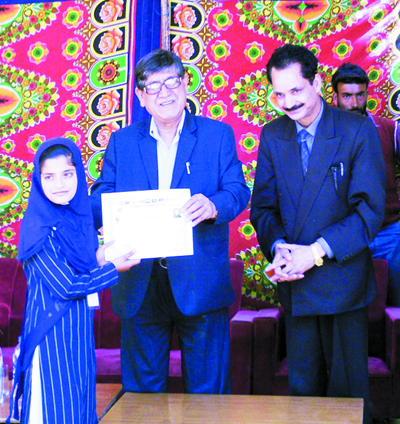 Minister for Higher Education, Mohammad Akbar Lone felicitating a winner in Srinagar.