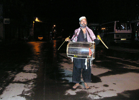 An elderly person popularly known as "Sehar Khan" beating drum during the third part of every night to awaken people for Ramadan Sehri in Safa Kadal area of down town Srinagar. (UNI)