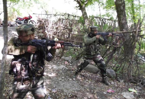 Security forces retaliating firing by militants trapped in a house at village Aripal, Tral in South Kashmir district of Pulwama on Saturday. (UNI)