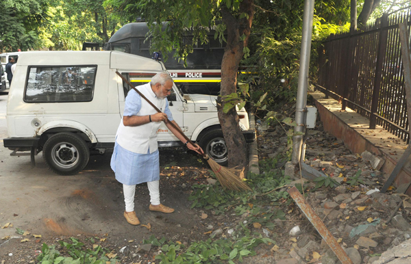 Prime Minister Narendra Modi cleaning the premises of Mandir Marg police station during his surprise visit in New Delhi on Thursday. (UNI)
