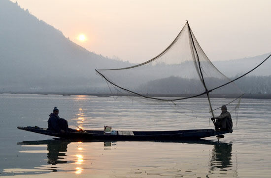 Fishermen cast their net in the Asia’s largest fresh water Wullar lake in north Kashmir’s Bandipora district on Friday. -Excelsior/Aabid Nabi
