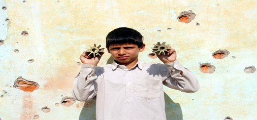 A boy shows mortar shells fired by Pakistan in Jora Farm of R S Pura sector on Monday.—Excelsior/Rakesh