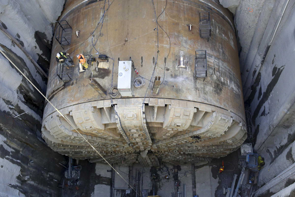 Workers make preparations to lift the cutting head from Bertha, the world's largest tunnel-boring machine, and lift it out for repairs in Seattle, Washington March 9, 2015. Bertha stopped working in December 2013 after digging just 10 percent of a planned tunnel to replace an aging waterfront highway, leaving crews scrambling to determine how to rescue and repair the 2,000-ton drill. REUTERS/UNI