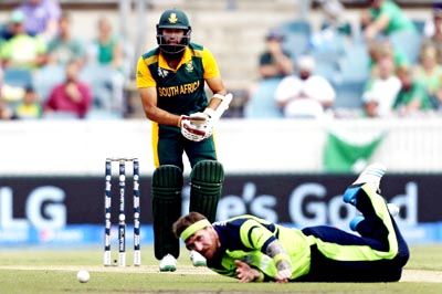 Ireland’s John Mooney (R) dives to try and field the ball hit by South Africa’s Hashim Amla of his marathon knock during Cricket World Cup match at Canberra. (UNI)