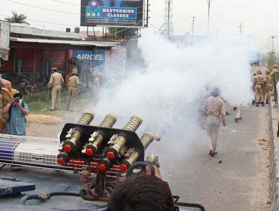 Cops firing teargas shells towards the mob at Ranibagh near Satwari on Thursday. -Excelsior/Rakesh