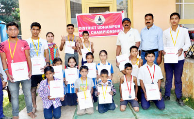 Medal winners of District Udhampur Yoga Championship displaying certificates while posing for a group photograph.