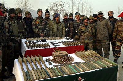 Troops pose with arms and ammunition recovered from Baramulla district on Tuesday. —Excelsior/Aabid Nabi