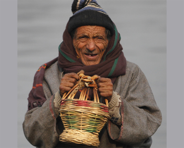 An elderly man warming his hands on the banks of Dal lake in Srinagar on Wednesday. -Excelsior/Amin War