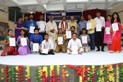 Students displaying certificates while posing for a group photograph during Annual Day celebration at Rashtriya Sanrkrit Sansthan.