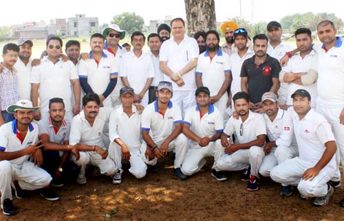 Participants of friendly cricket match posing for group photograph.