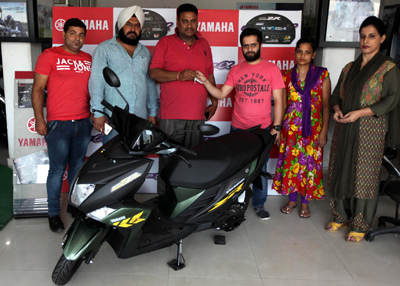 Managing Director of Royal Motors, Channi Rama, Narwal handing over Yamaha Cygnus Ray-ZR scooter keys to a customer.