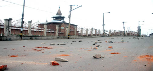 A road filled with stones as Srinagar remained under curfew on Friday. — Excelsior / Shakeel