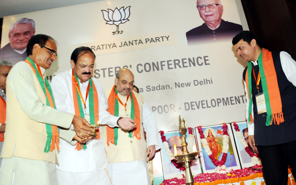 BJP President Amit Shah with Union Minister of Urban Development and Information and Broadcasting M Venkaiah Naidu and Chief Ministers of Madhya Pradesh Shivraj Singh Chouhan and Maharashtra Devendra Fadnavis lighting the lamp to ianugurate the Chief Ministers' Conference (Mukhyamantri Parishad) in New Delhi on Saturday. (UNI)