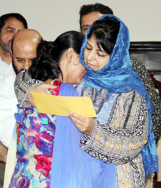 Chief Minister Mehbooba Mufti consoles a girl as she hands over appointment letter to her in Jammu on Monday.