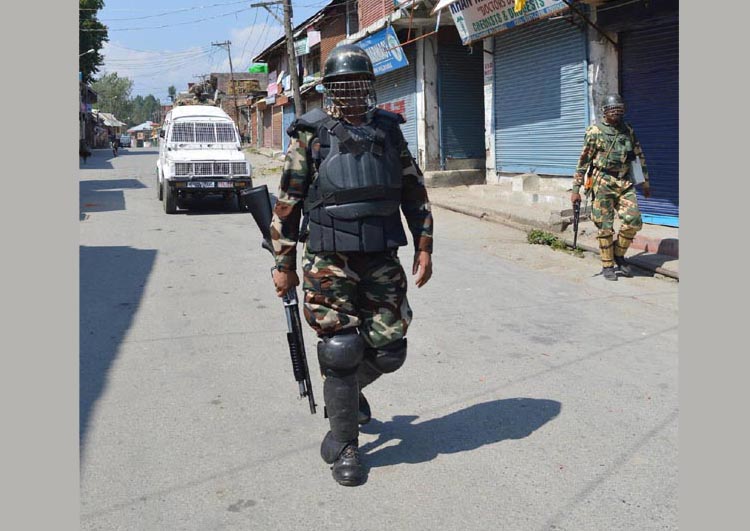 Jawans patrol a deserted road in Pulwama town during curfew on Wednesday. -Excelsior/Younis Khaliq