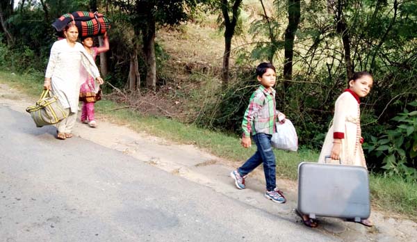People including children trek to safer places in Nowshera sector of Rajouri district on Wednesday. -Excelsior/Bhat
