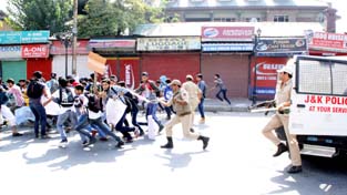 Policemen cane charging students at Lal Chowk on Sunday. -Excelsior/Shakeel-ul-Rehman