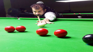 Cueist aiming at target during a match of State Senior Snooker Championship at MA Stadium.