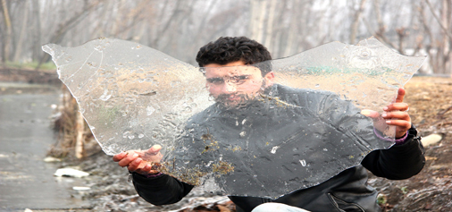 A boy shows a piece of frozen ice on the banks of Dal lake in Srinagar on Monday. —Excelsior/Shakeel