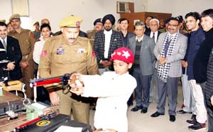 Young shooter displaying his skills while DGP Dr S P Vaid and other dignitaries watch him during felicitating function in Jammu.