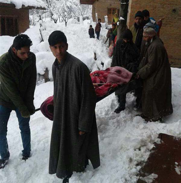 The pregnant woman being carried to hospital through snow clad route in Rafiabad on Saturday.