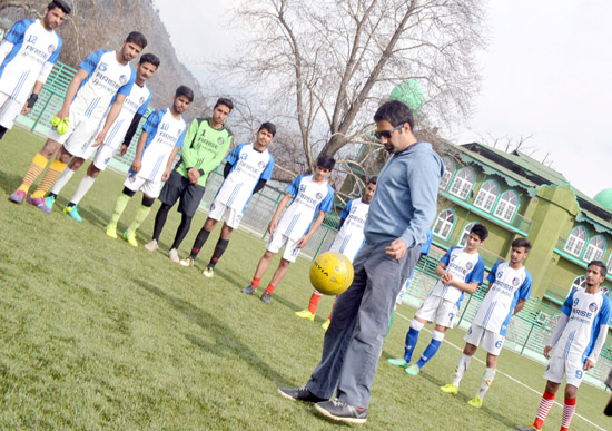 PDP’s Anantnag constituency candidate Tasaduq Mufti playing football with ‘Khelo India Khelo’ football players at Pologround in Srinagar on Friday. -Excelsior/ Shakeel