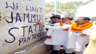 NPP leader B S Mankotia launches wall writing campaign for Jammu state at R S Pura on Friday.