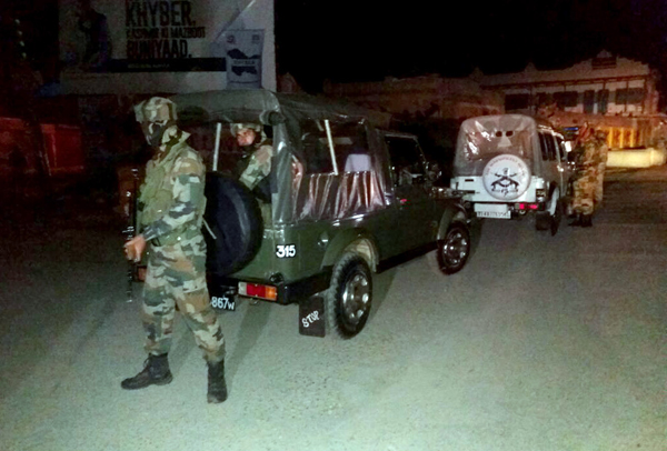 Cops take positions after militants ambush at Pantha Chowk in Srinagar on Friday evening. -Excelsior/Shakeel