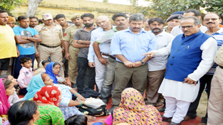 Deputy Chief Minister Dr Nirmal Singh interacting with shelling hit people on Friday.