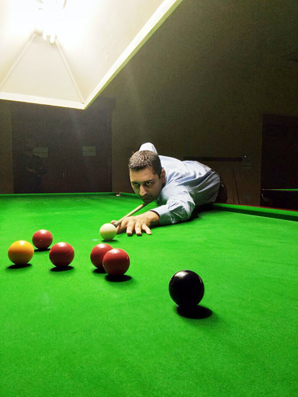 Cueist aiming at target during a match of State Senior Snooker Championship at Billiards Hall in MA Stadium.