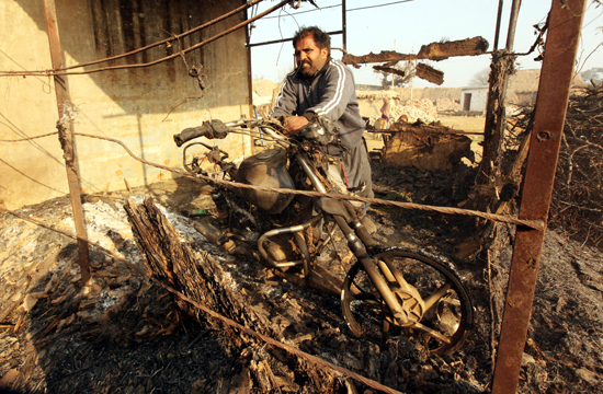 A man tries to remove remnants of his burnt motorcycle in Jeora Farm of R S Pura Sector, where number of ‘Kullahs’ were gutted in Pakistan shelling on Saturday.