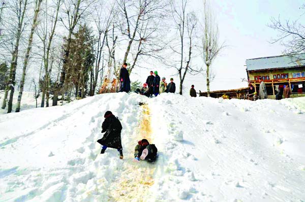 Children playing sledges on snow covered hilly road on the outskirts of Srinagar. —Excelsior/Shakeel