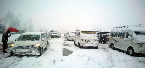 Vehicles covered with snowfall stranded at National Highway on Monday. Another pic on page 11. -Excelsior/Sajad Dar