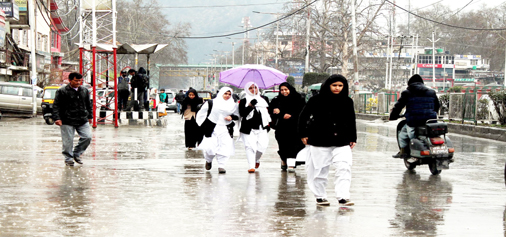 Umbrellas out in Srinagar as Kashmir valley experienced torrential rains disrupting normal life on Wednesday. (UNI)
