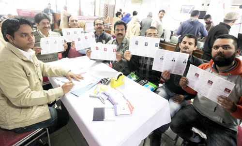 People displaying their registration forms at PNB branch, Rehari where they turned up for their enrolment for this year's holy Amarnath yatra on first day of registration on Friday. -Excelsior/Rakesh