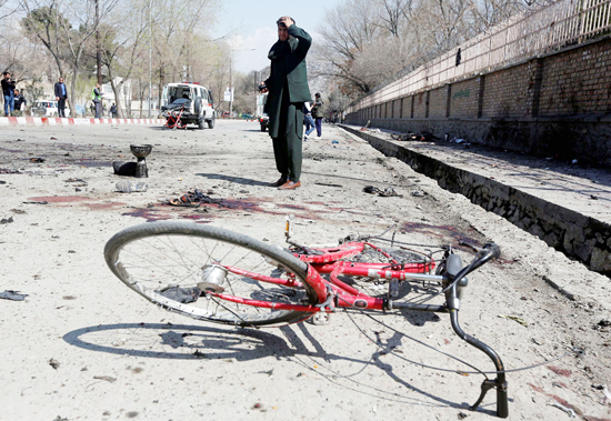 An Afghan man inspects the site of a suicide attack in Kabul, Afghanistan on Wednesday.
