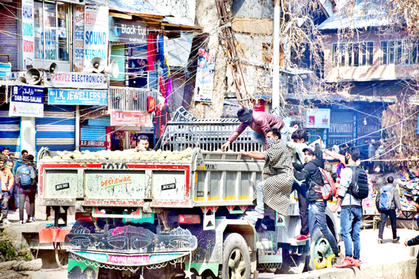 Youth collect stones from a tipper for pelting on para-military and police personnel in Pulwama town on Monday.