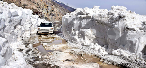 A vehicle moves on snow bound Mughal road on Monday. -Excelsior/Younis Khaliq
