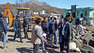 A JCB demolishing illegal structures raised on Govt land at Koteranka.