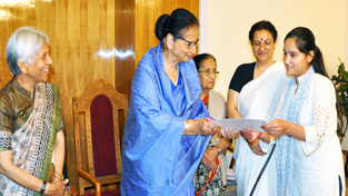 First Lady Usha Vohra presenting certificate to a girl on completion of basic computer course.