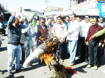 Protesting contractors torching effigy of Finance Minister at Kathua on Friday. -Excelsior/ Pardeep