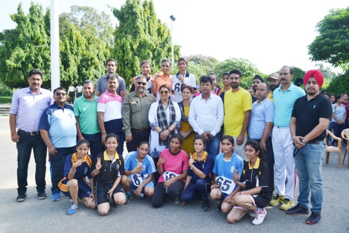 Women Athletes posing along with digniatries with officials after Cross Country organised by JU.