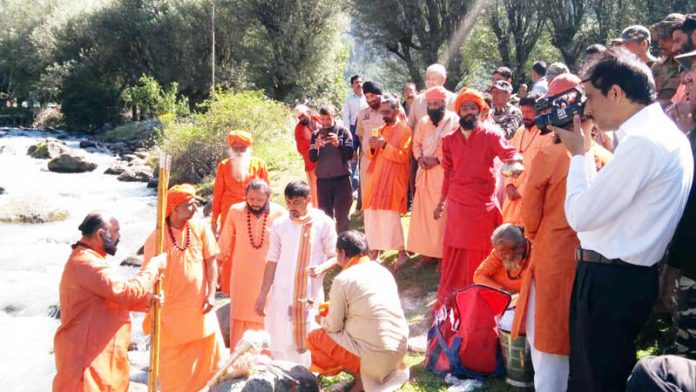 Sadhus & devotees led by Mahant Deependra Giri Ji, the sole custodian of holy mace performing immersion ceremony and the rituals at bank of river Lidder in Pahalgam on Tuesday. -Excelsior/ Sajjad Dar