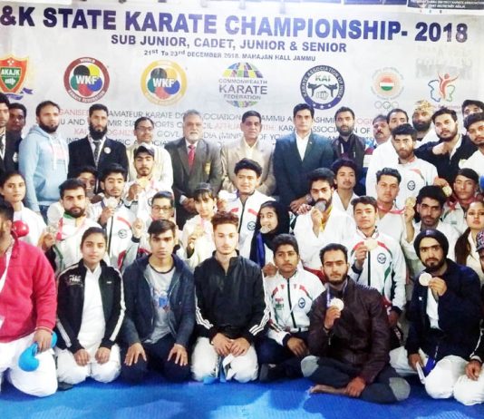 Karatekas after winning medals in State Championship posing along with dignitaries and officials in Jammu.
