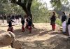 Students playing in open under supervision of teachers as school sans boundary wall.