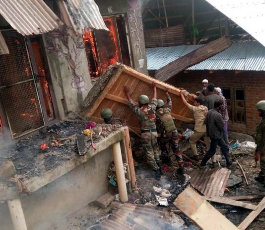 Armymen salvaging household items during fire in a house at Ganai Mohalla, Dudbug, Baramulla.