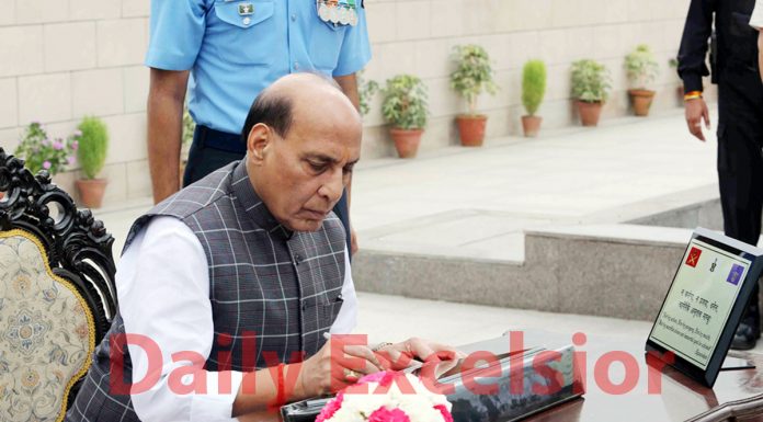 Defence Minister Rajnath Singh signing the visitors' book after paying homage to martyrs on the occasion of the 20th anniversary of Kargil Vijay Diwas at the National War Memorial in New Delhi on Friday.