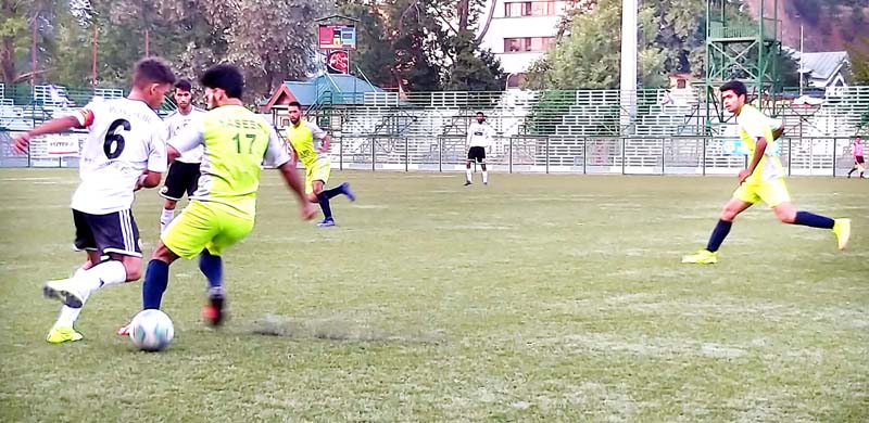Footballers in action during a match of JKFA Annual League Football Tournament at TRC ground in Srinagar. 